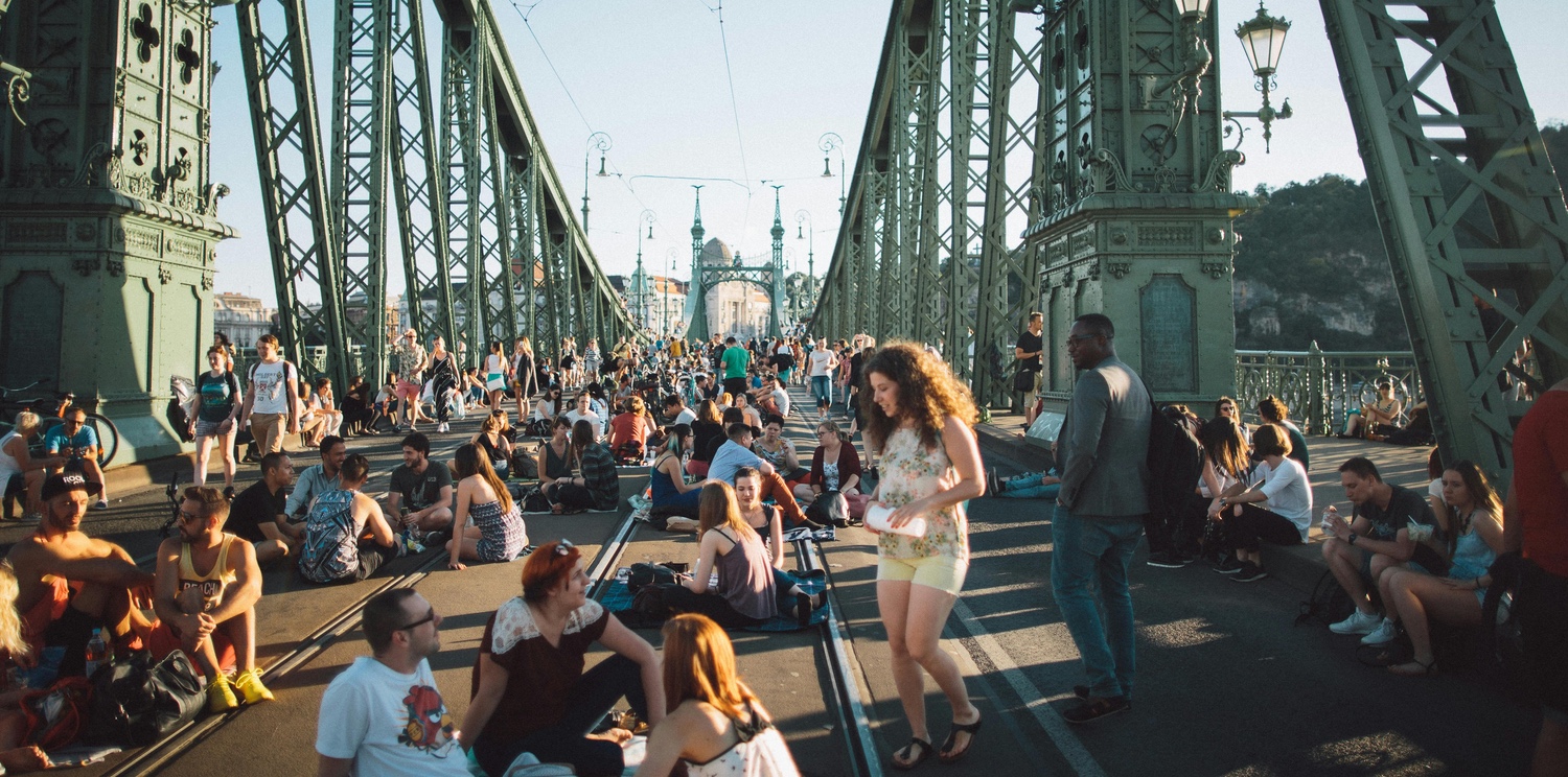 People Sitting on the Road of Liberty Bridge in Budapest